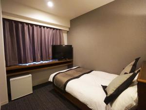 a hotel room with a bed and a window at Hotel Areaone Kochi in Kochi