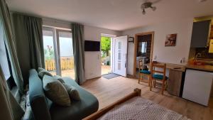 a living room with a blue couch and a kitchen at Haides helle Wohnung in Neckarsteinach