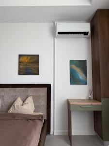 une chambre avec un lit et un bureau à côté d'un mur dans l'établissement AXXIS Nova Resort & SPA Mamaia Nord C108, à Mamaia 3 autres photos