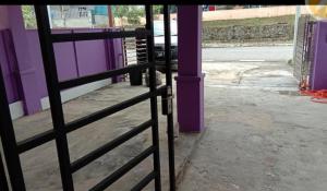 a metal gate in front of a purple building at Humairah Home Stay in Ranau