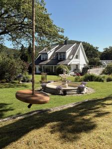 a house with a bird bath in the yard at Stylish Villa - Boat, Greenhouse & Majestic Oaks in Sørvåg
