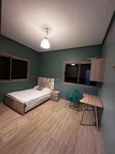 a bedroom with a bed and a table and windows at Villa avec piscine in Meknès