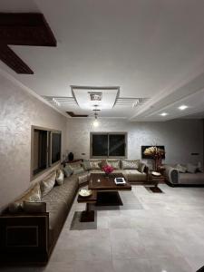 a large living room with a couch and a table at Villa avec piscine in Meknès