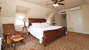 a bedroom with a bed and a chair and a ceiling fan at Saltwood House in Cape May