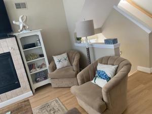 a living room with two chairs and a fireplace at Oceanside Brant Beach Single Family Beach Badges Private Yard Wifi Ocean And Bay Views Washer & Dryer This Home Will Allow You To Truly Feel in Brant Beach