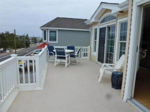 a deck with chairs and a table on a house at Oceanside Brant Beach Single Family Beach Badges Private Yard Wifi Ocean And Bay Views Washer & Dryer This Home Will Allow You To Truly Feel in Brant Beach