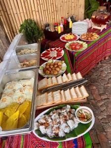 a buffet with many different types of food on plates at Pura homestay in Yên Minh