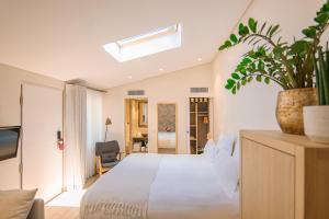 a bedroom with a white bed and a plant on a dresser at Boutique Hôtel Villa Fabulite in Antibes