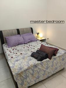 a bed with two pillows on it in a bedroom at Win & Sha's Homestay in Miri
