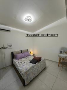 a bedroom with a bed with purple pillows on it at Win & Sha's Homestay in Miri +12 photos