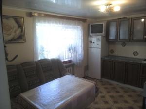 a kitchen with a table and a white refrigerator at Гостевой дом у моря in Odesa