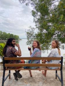 two women and a man sitting on a bench at FREEDOM HOUSE, Munroe Island , Kollam - A Backpackers Hostel in Munroe Island