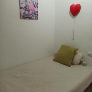 a bedroom with a bed with a heart balloon on the wall at Nathally room's Gandía in Gandía