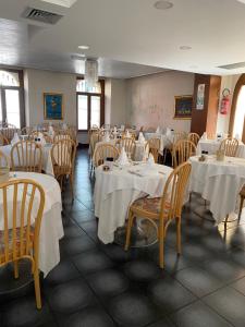 a dining room with tables and chairs with white tablecloths at Hotel Malcesine in Malcesine +35 photos
