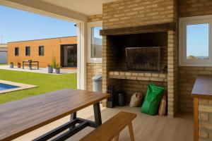 d'une terrasse avec une cheminée en briques et une table en bois. dans l'établissement Casa Lucas&Cloe - Refuge Between Marshlands and Sea, à Barbate