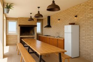 une cuisine avec une table en bois et un réfrigérateur dans l'établissement Casa Lucas&Cloe - Refuge Between Marshlands and Sea, à Barbate