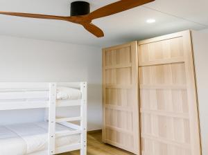 une chambre avec deux lits superposés et un ventilateur de plafond dans l'établissement Casa Lucas&Cloe - Refuge Between Marshlands and Sea, à Barbate 37 autres photos