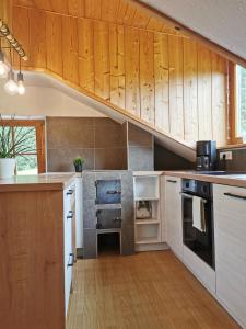 a kitchen with wooden cabinets and a staircase at Haus Maria in Campolasta
