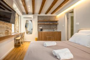 a bedroom with a bed with two towels on it at Diocletian's Suites Centre Palace in Split