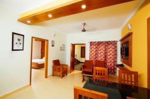 a living room with a couch and a room with a bed at SHALOM RESIDENCY in Kakkanad