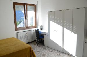 a bedroom with a bed and a desk and a window at Top Floor Apartment 5 minutes walk to lake in Malgrate