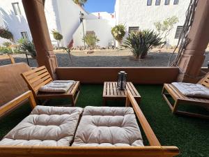 un patio con dos sillas y un sofá en el suelo en Oasis Jaylota, en Corralejo