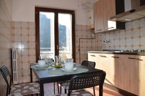 a table and chairs in a kitchen with a table and a window at Top Floor Apartment 5 minutes walk to lake in Malgrate
