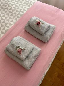 two towels on a bed with a pink blanket at Ninho da Irene in Vieira de Leiria