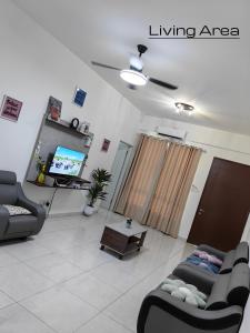 a living room with two couches and a tv at Win & Sha's Homestay in Miri
