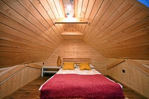 a bedroom with a bed in a wooden room at Apartamenty Poza Horyzont in Korbielów
