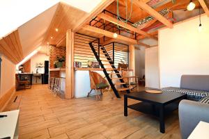 a living room with a staircase and a table at Apartamenty Poza Horyzont in Korbielów