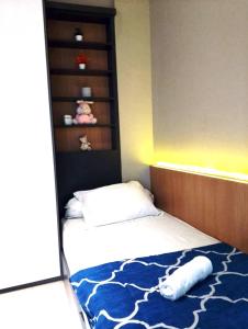 a bedroom with a bed with a blue and white rug at The Asando Above Pakuwon Mall in Lontar +47 photos