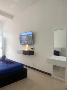 a bedroom with a bed and a tv on the wall at Zentara Ella by silkfive in Ella
