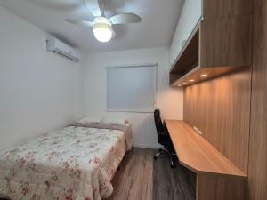 a bedroom with a desk and a bed with a bedspread at Apartamento TOP 2 quartos e 2 vagas garagem in Balneário Camboriú