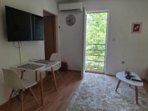 a living room with a table and a keyboard at Apartment Lilac Sarajevo in Sarajevo