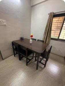 a dining room table with a vase of flowers on it at Snehal's Homestay Hosting Only Families in Nashik +15 photos