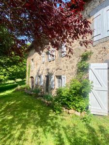an old stone house with a white garage door at Le 1830 in Églisolles
