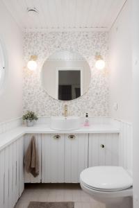 a bathroom with a sink and a toilet and a mirror at Omakotitalo Jyväskylän keskustassa in Jyväskylä +17 photos