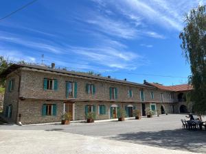 a large brick building with green shutters on it at Evoluzioni - Agriturismo in Prunetto
