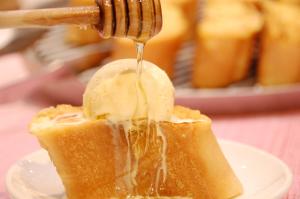 a honey being drizzled onto a piece of food at Hotel Global View Hakodate in Hakodate