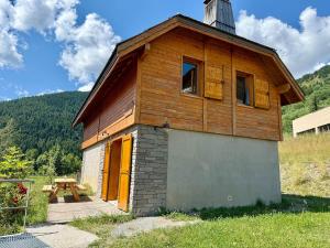 a small wooden building with a table in front of it at Cozy Mountain Cottage Pra loup in Uvernet-Fours