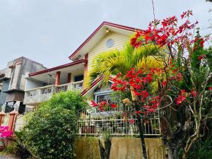 a house with red flowers and a fence at Cindys Get away in Ulot