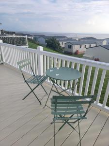 a table and two chairs on a deck with a view at Heysham seaview in Heysham