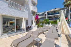 a row of lounge chairs and umbrellas in front of a building at Sezin Apart in Marmaris