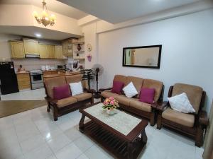 een woonkamer met twee banken en een salontafel bij RIVERBANK SUITE with riverfront mountain DUN view in Kuching