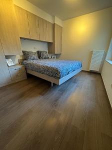 een slaapkamer met een bed en een houten vloer bij MeretMoi -- Modern appartement in Oostende in Oostende