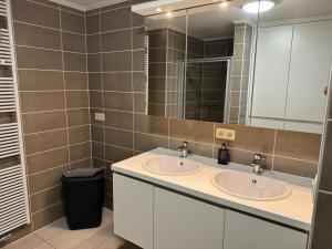 een badkamer met twee wastafels en een spiegel bij MeretMoi -- Modern appartement in Oostende in Oostende +4 foto's