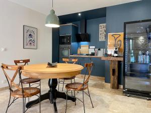a dining room with a wooden table and chairs at Le saint G in Augé