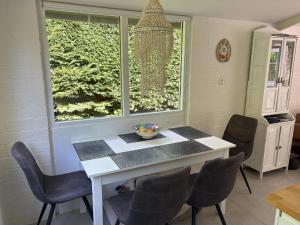 una sala da pranzo con tavolo, sedie e una finestra di Gemütliches, helles Ferienhaus mit privatem Garten in gepflegtem Ferienpark a Warmenhuizen