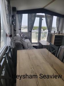 a dining room with a table and a large window at Heysham seaview in Heysham